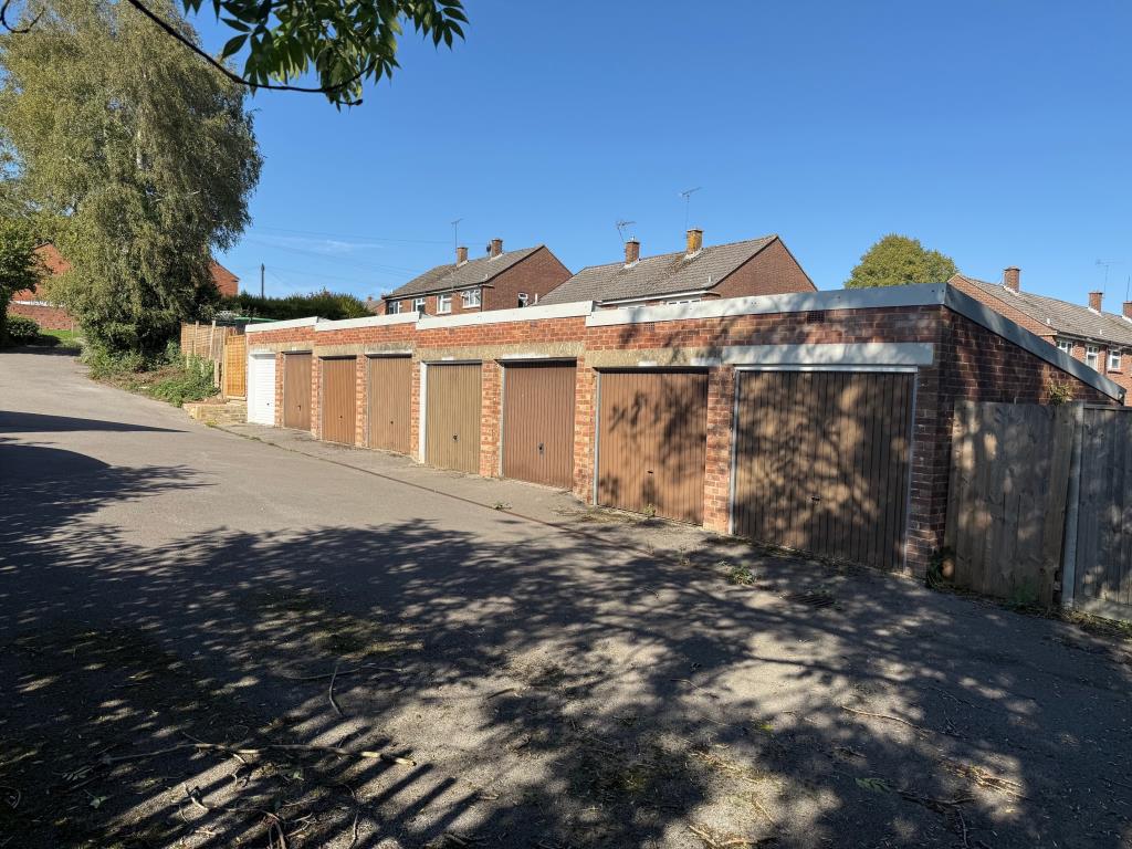 Lot: 27 - GARAGE BLOCK WITH CONSENT FOR CONSTRUCTION OF TWO HOUSES - Block of eight garages looking up the hill